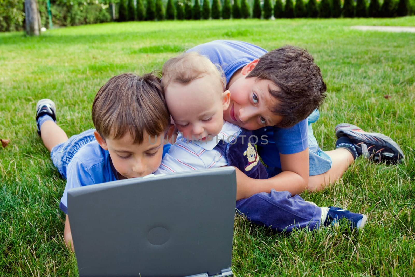 Three cute brothers study on computer 