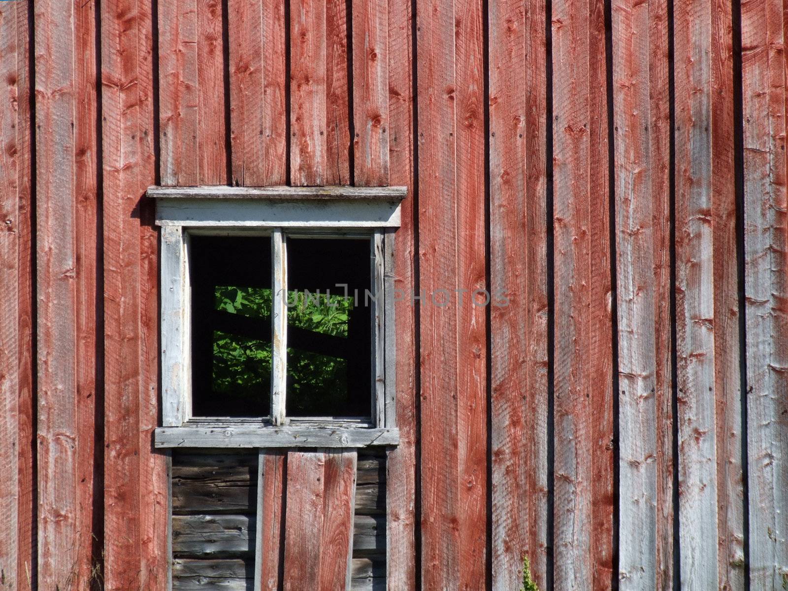 Empty window without glass in an old Norwegian farm building.