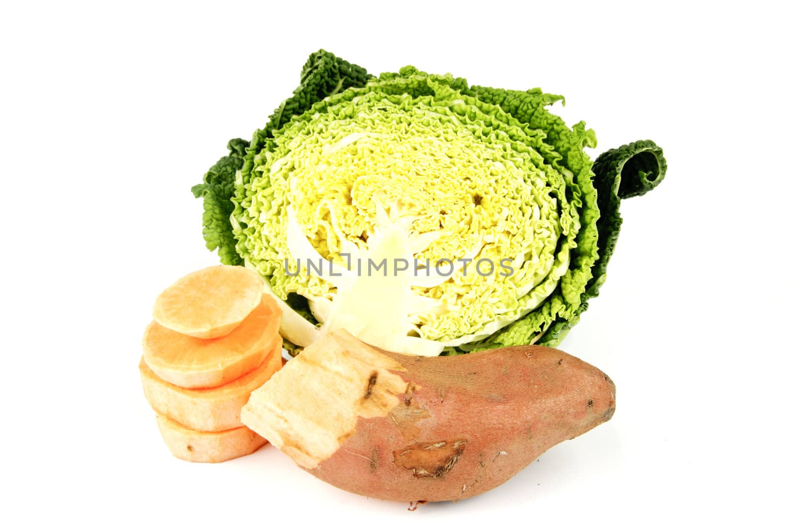 Half a raw green cabbage on a reflective white background