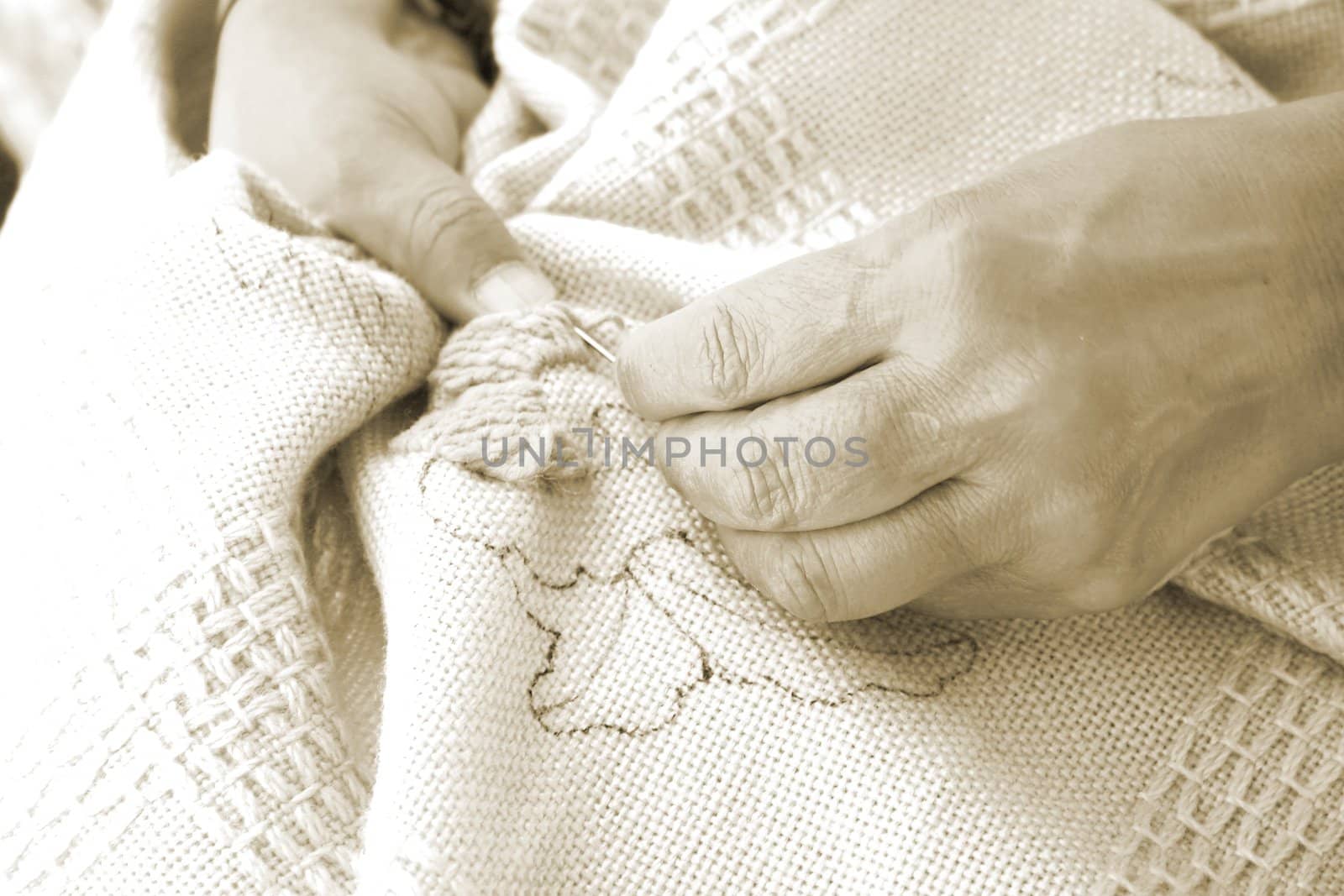 Woman using woollen yarn to embroider fabric