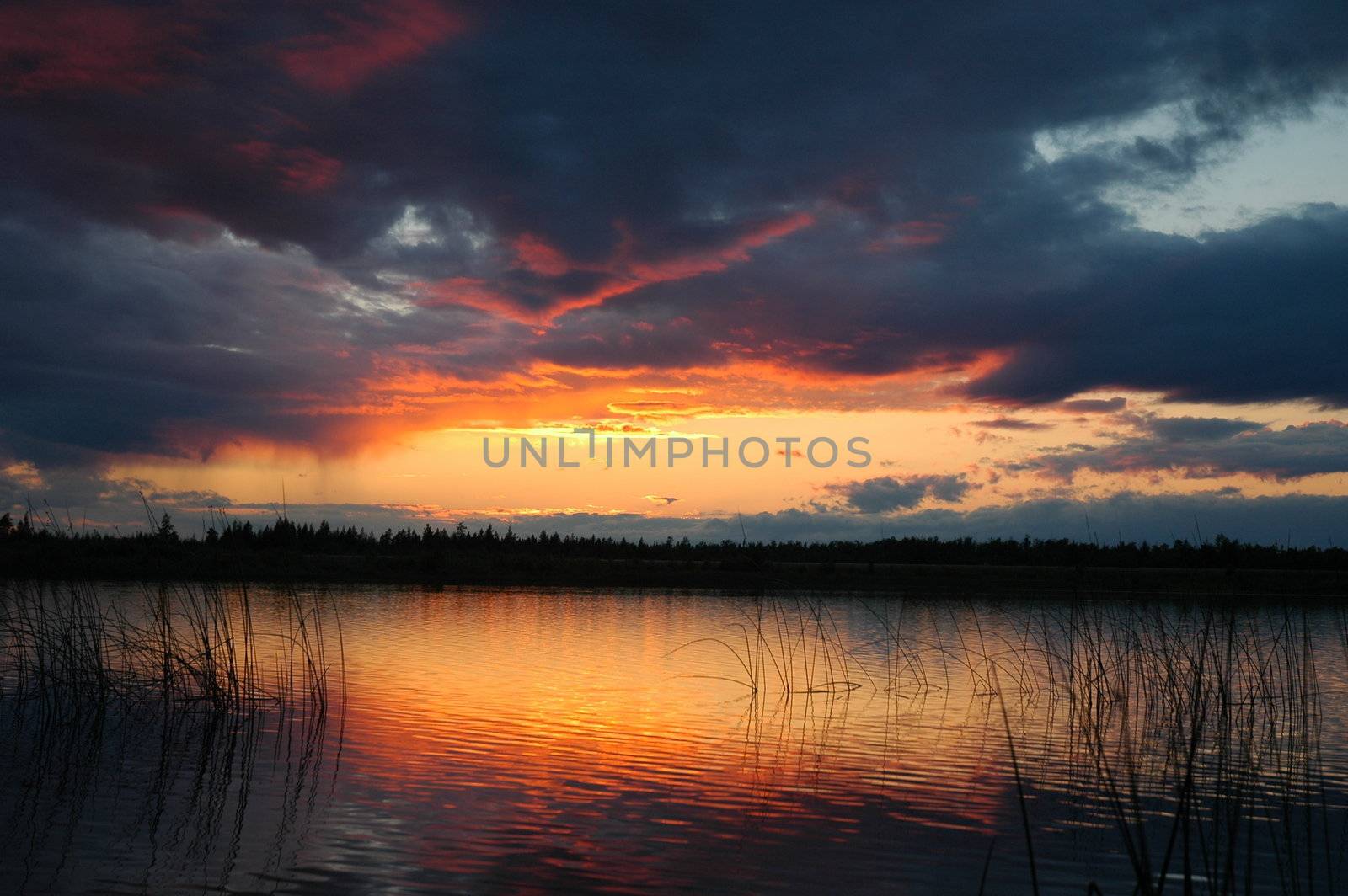 Colorful sunset reflecting on small lake in Northern, Ontario
