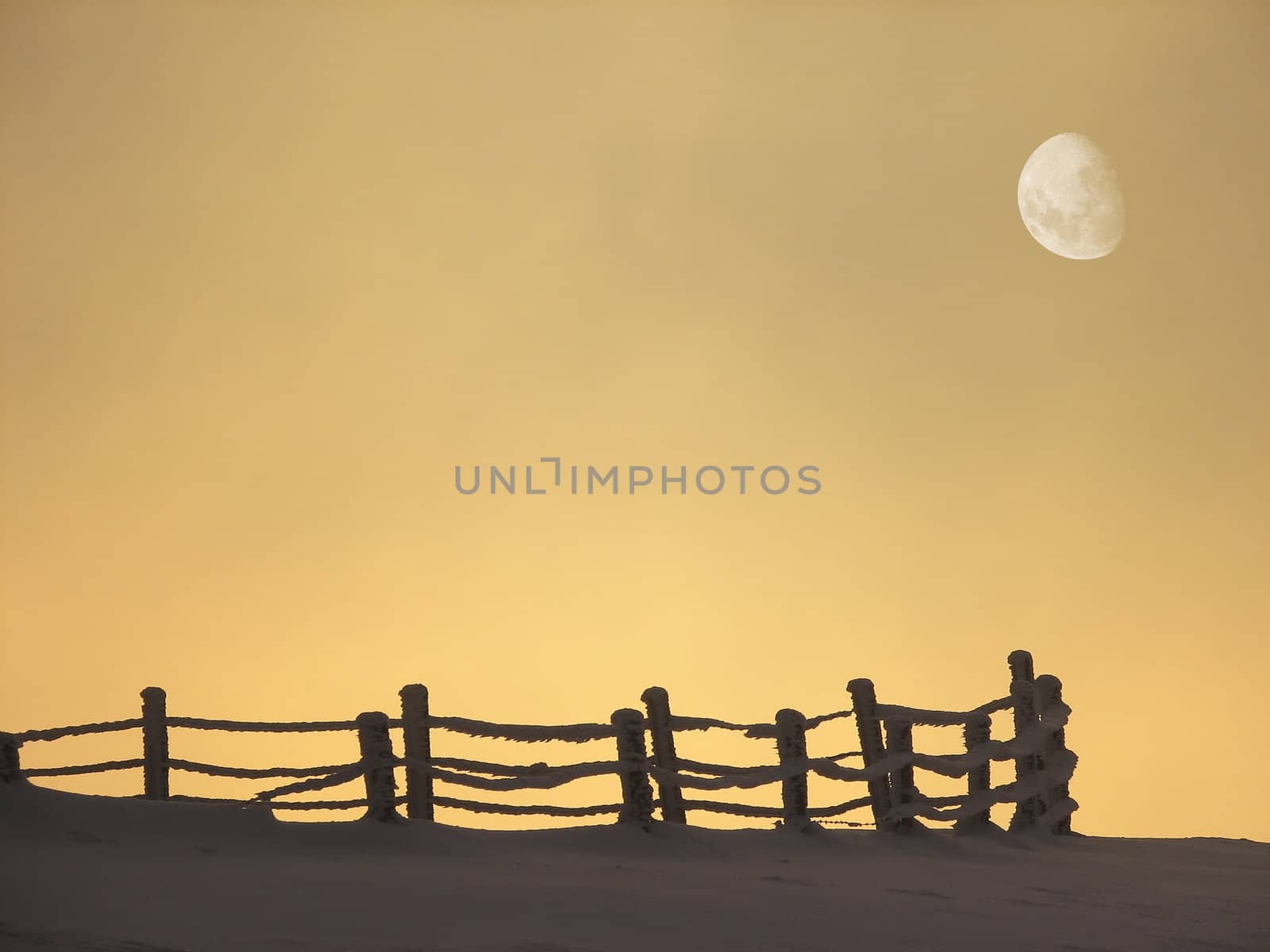 Winter landscape at sunset with fence and moon