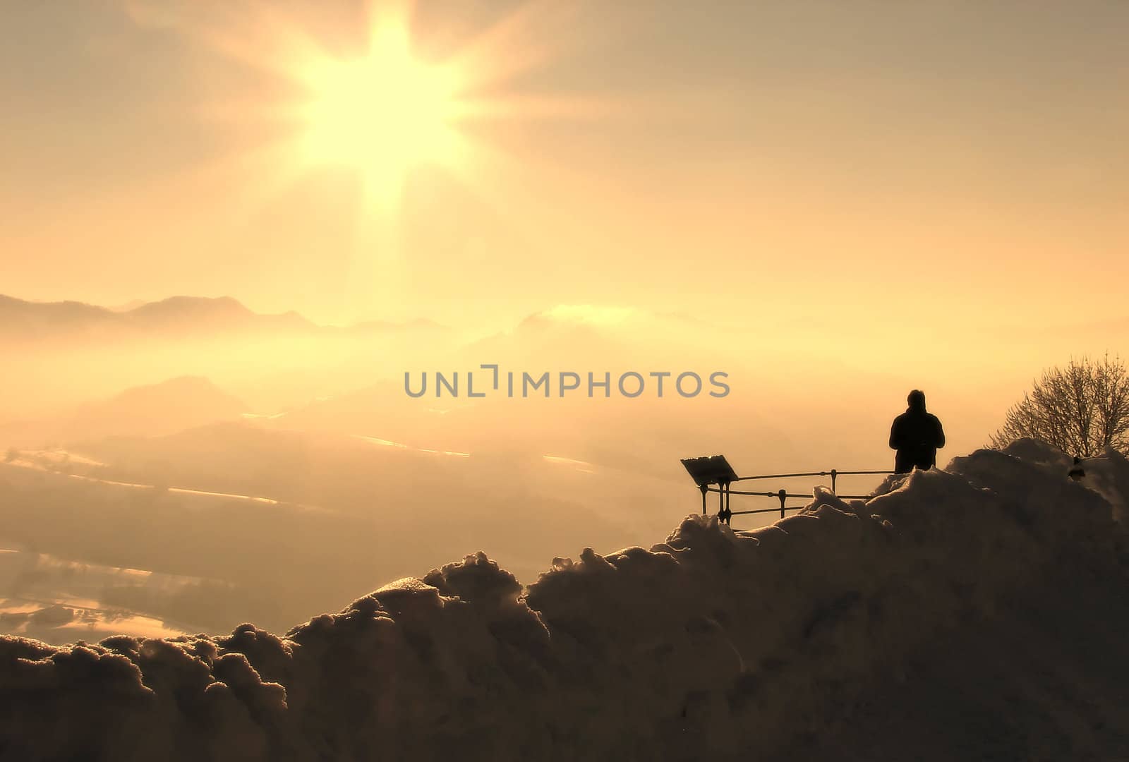 Silhouette of a man in a winter landscape looking at the mountains in the distance
