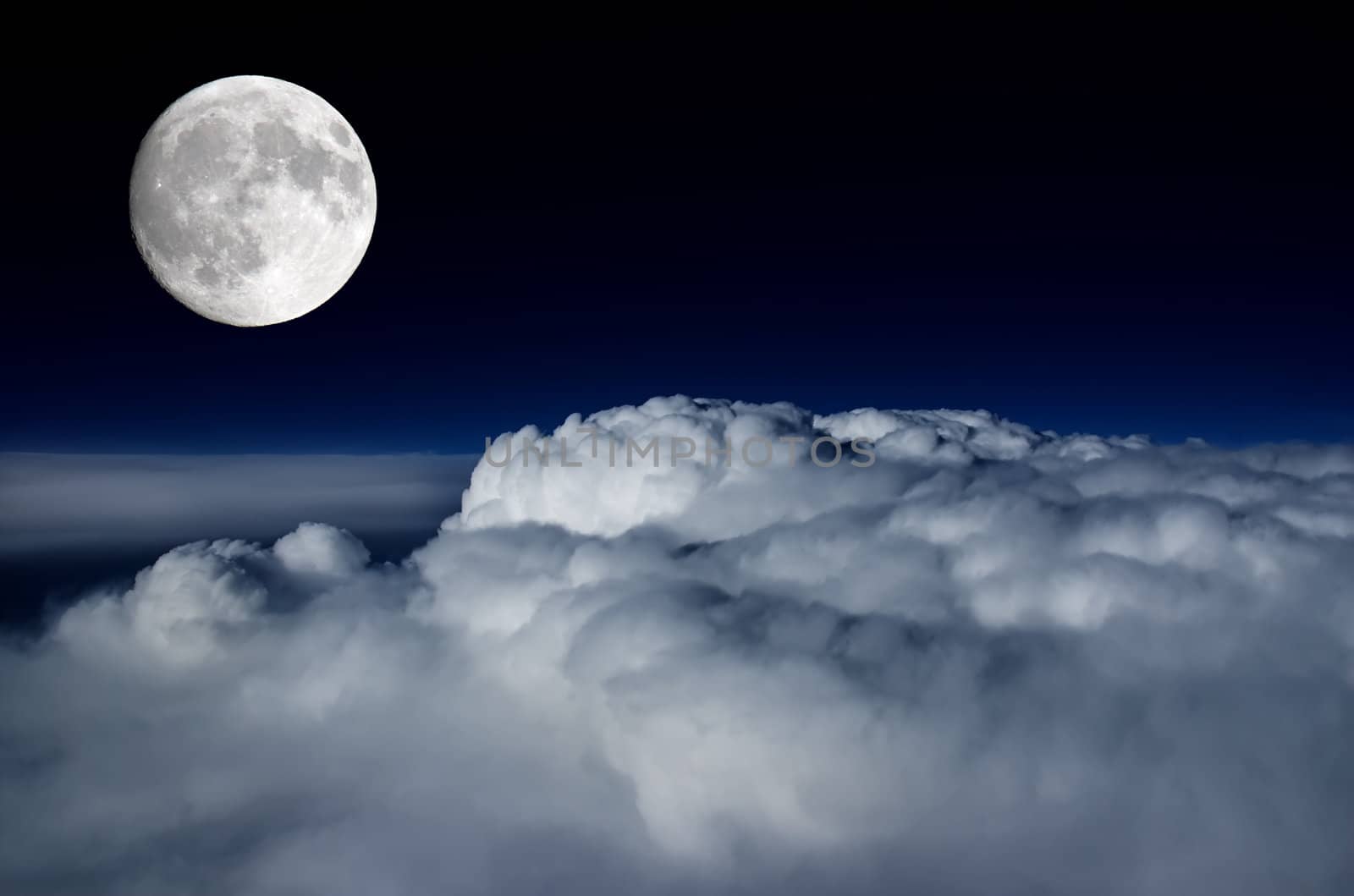 Full moon lighting up the clouds below