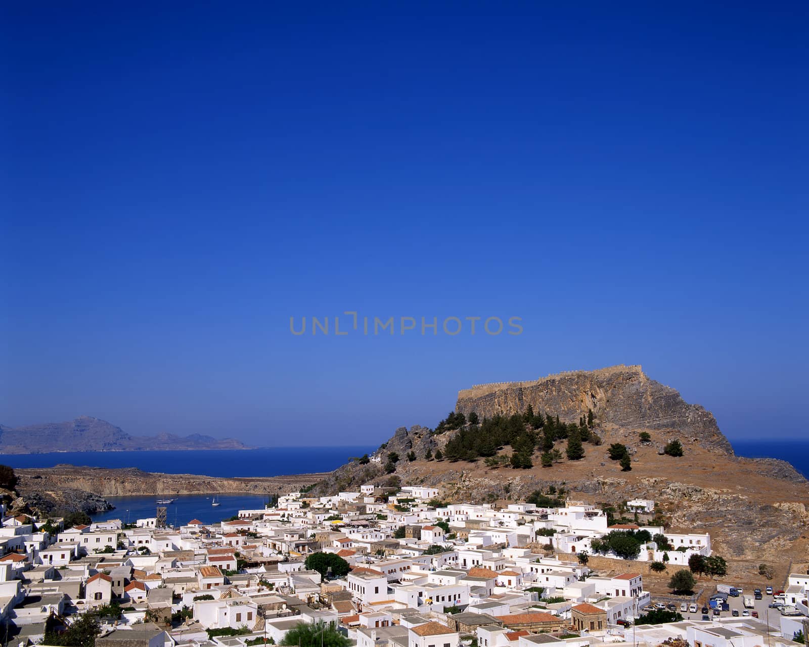 View looking over the town of Lindos, Rhodes, Greece with the castle in the background.
