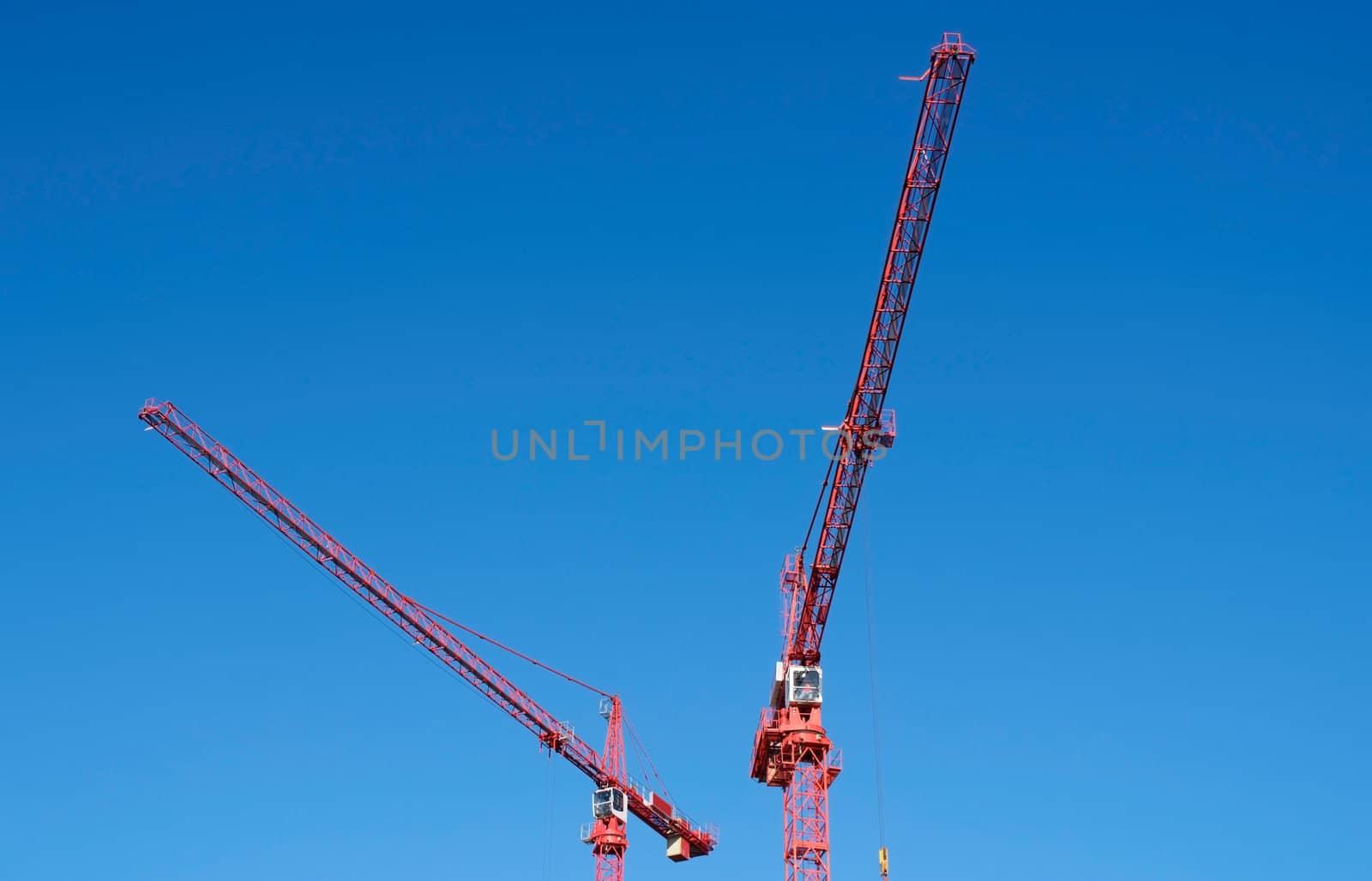 Two cranes working high above city