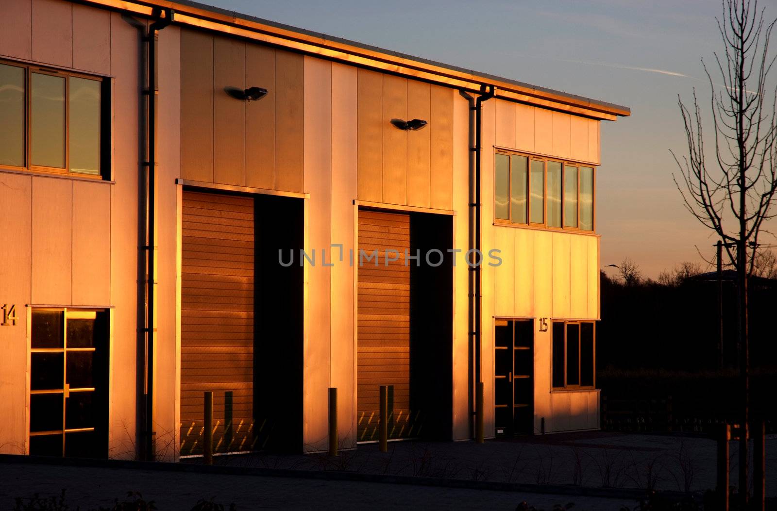 Sun setting and lighting up the side of a modern industrial unit in yellow