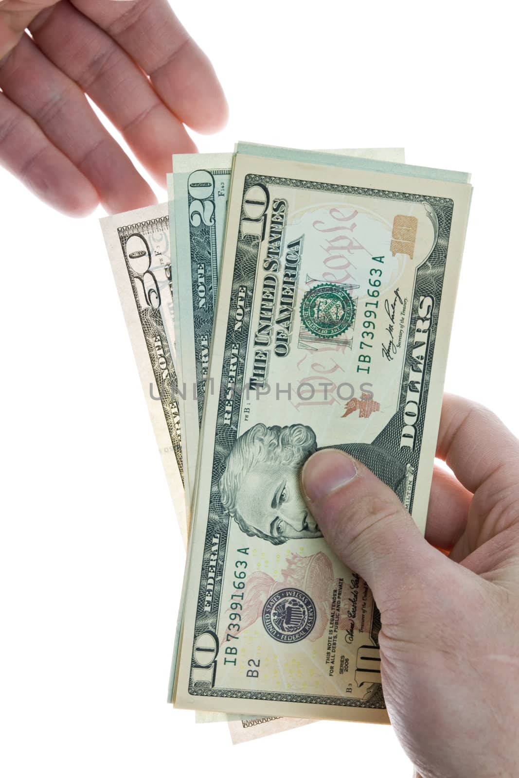 Hand giving a stack of dollar bills to someone else's hand. Isolated on a white background.