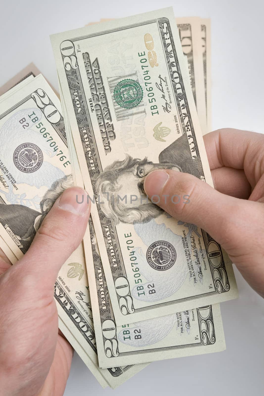 Pair of hands holding a stack of dollar bills.