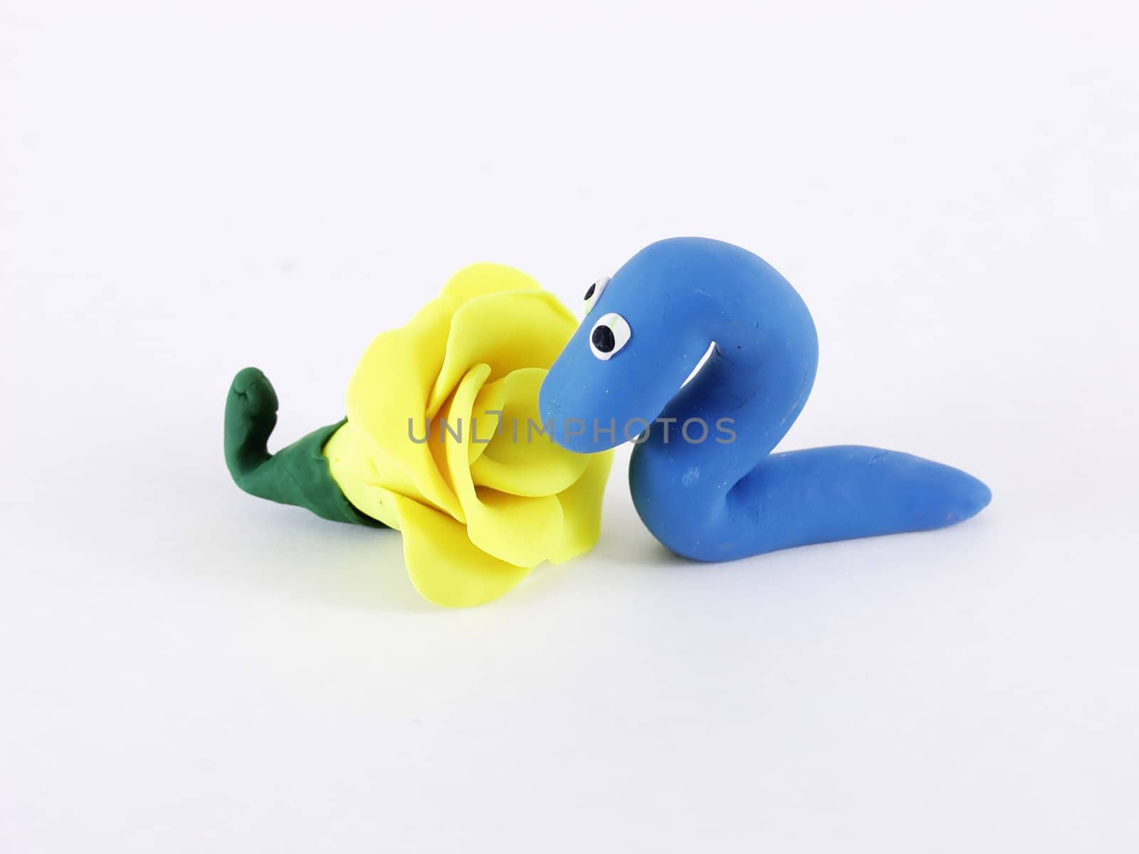 A blue worm sniffs a yellow rose. On a white background. Photographer holds copyright on all figurines.