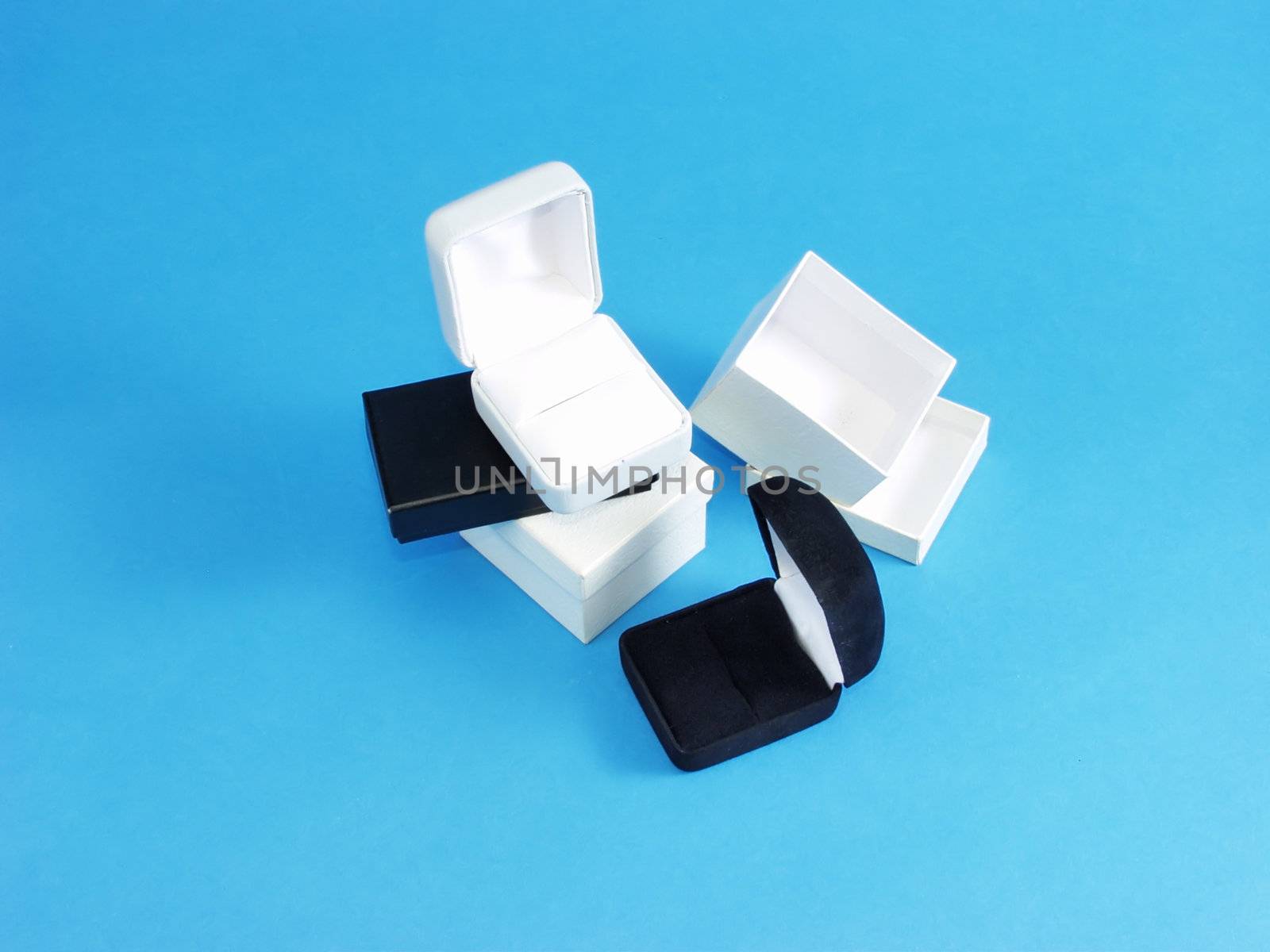A set of two jewelry boxes, one black, one white, on an isolated blue background