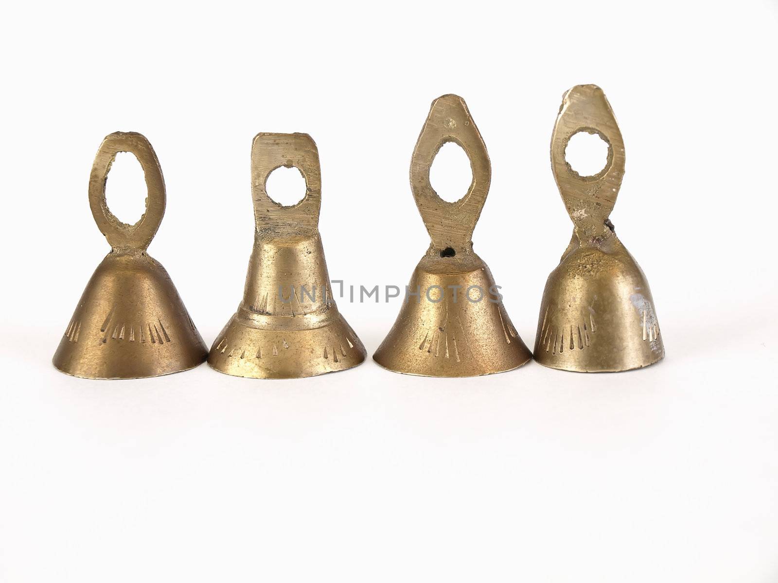 Four brass bells isolated on a white background.