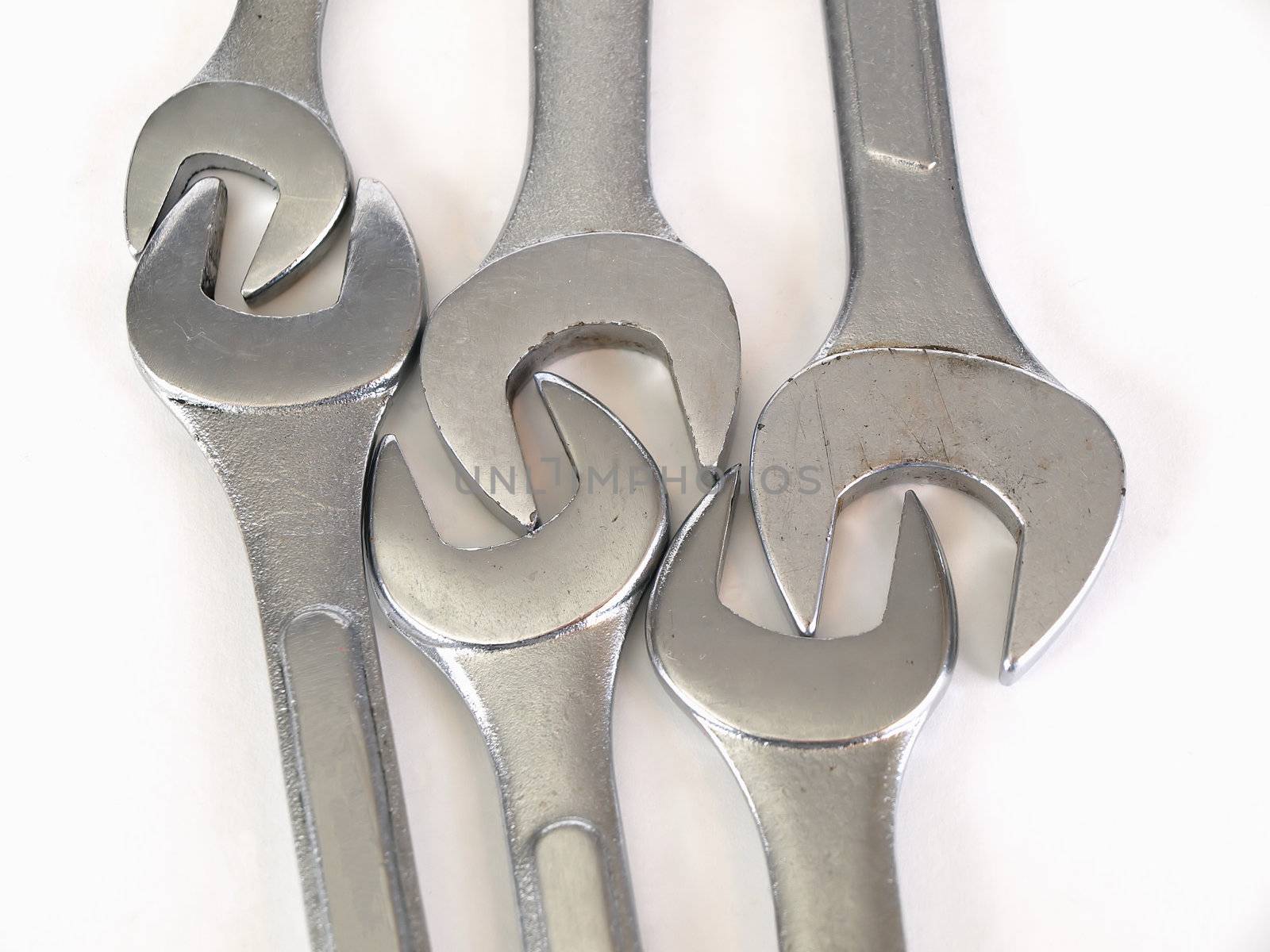 Six crescent wrenches, interlocked, on a solid white background.