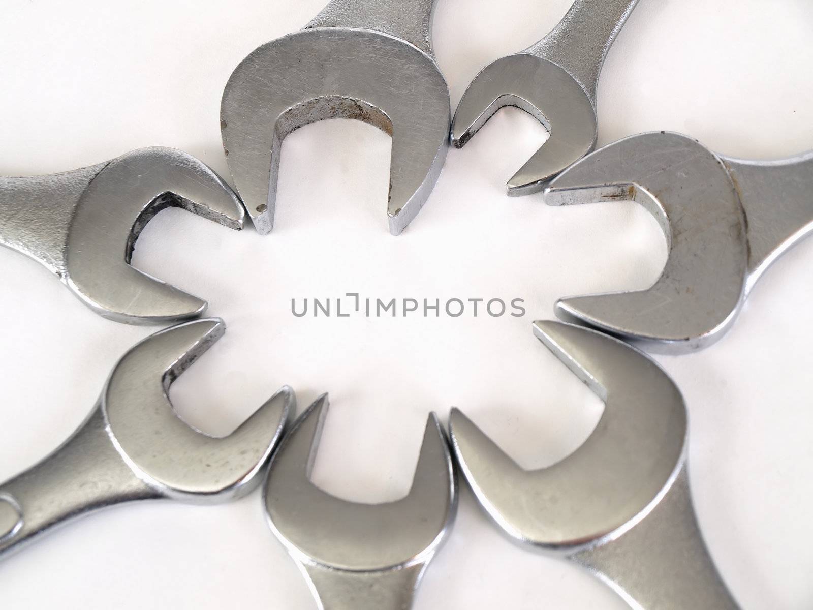 Crescent wrenches set in a flower bloom pattern over a white background.