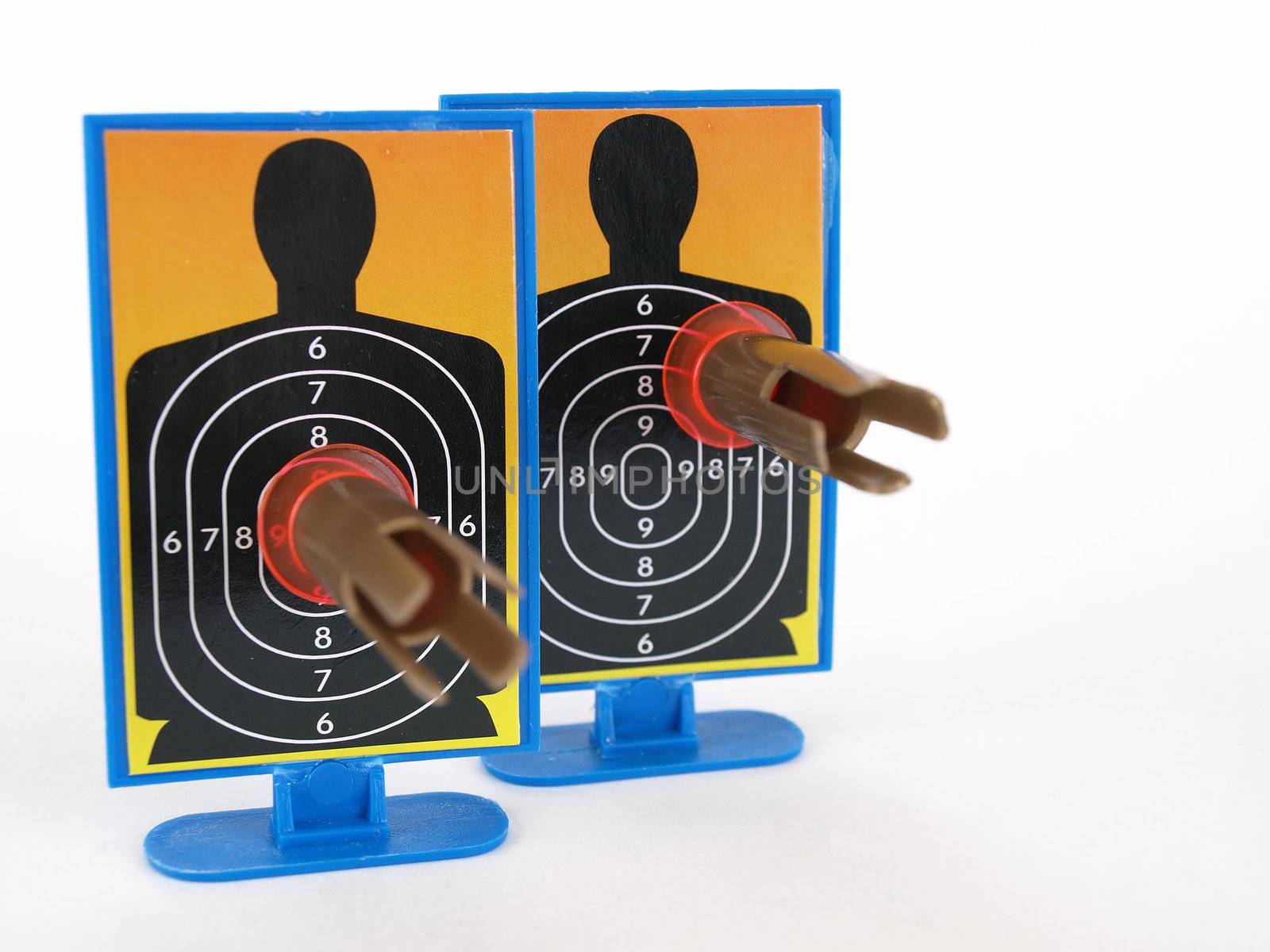 Two target silhouettes with suction cup darts attached to them. Over a white background.