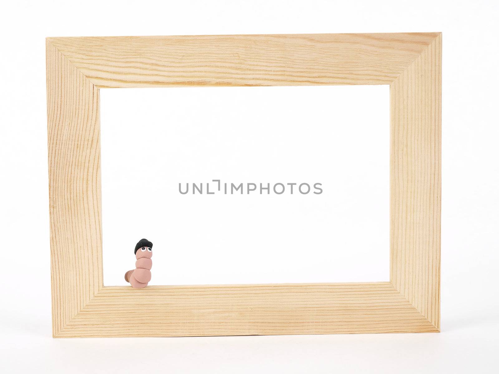 A cute EarthWerm in a bowler hat sits on the edge of a blank tan wood frame over a white background. Photographer holds copyright on figurines.