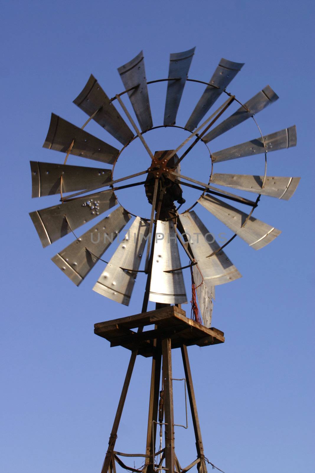 An old windmill still pumping water on a cattle ranch in the foothills of the Colorado Rocky Mountains