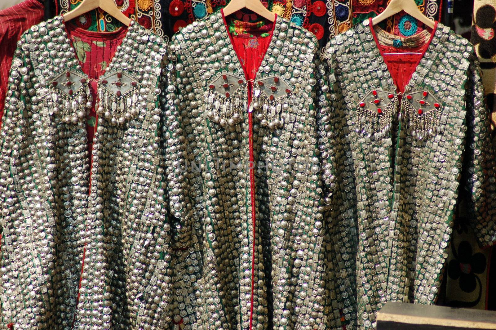 Three chain-mail capes hanging on clothes hangers in Camden Market
