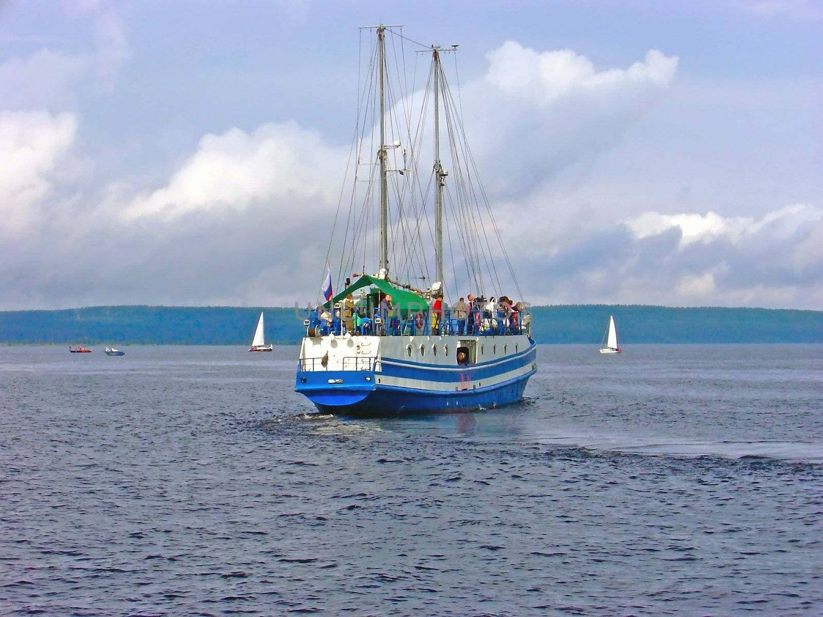 yacht with passengers against the coastline
