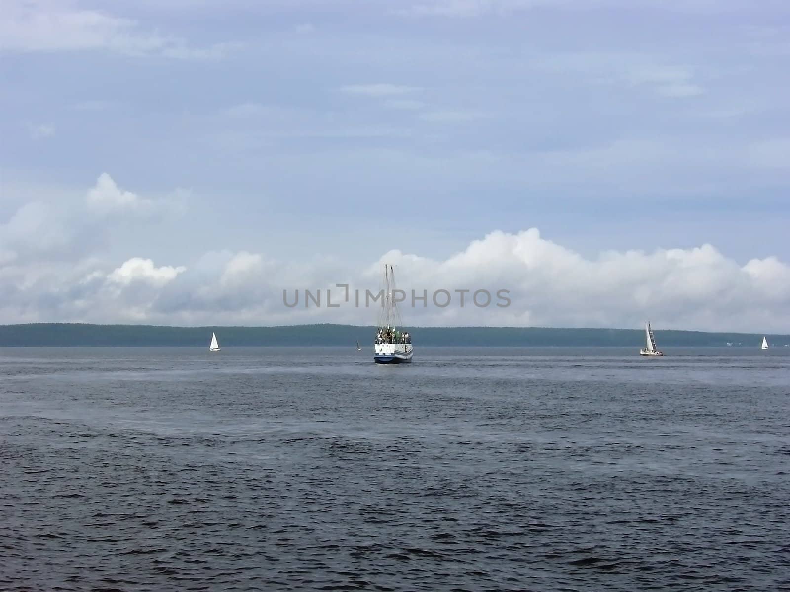 yachts against the coastline with the clouds