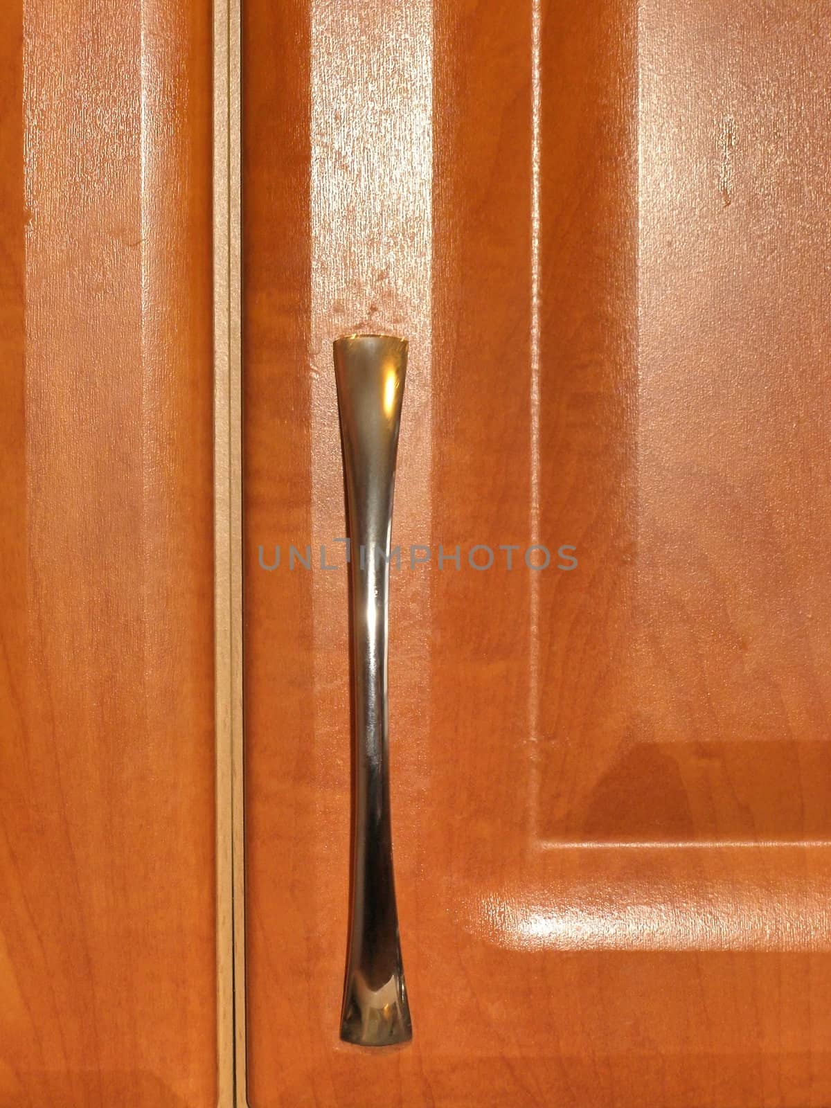 The wooden brown door with metallic handle