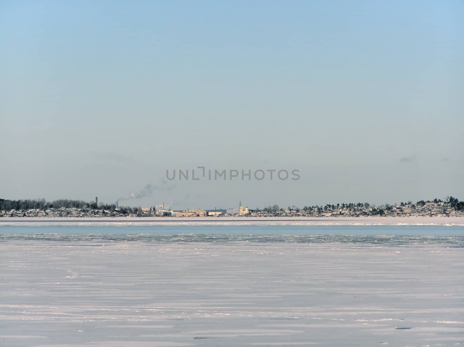 Tranquil winter lake skyline with the blue sky and town