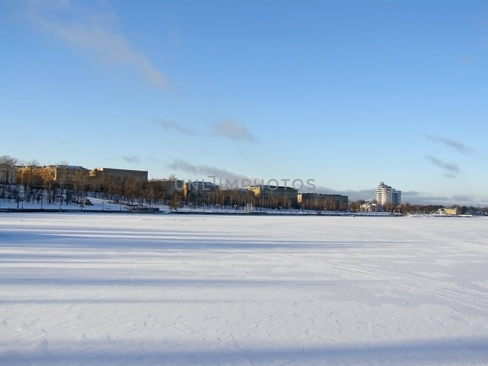Tranquil winter lake skyline with the blue sky and town