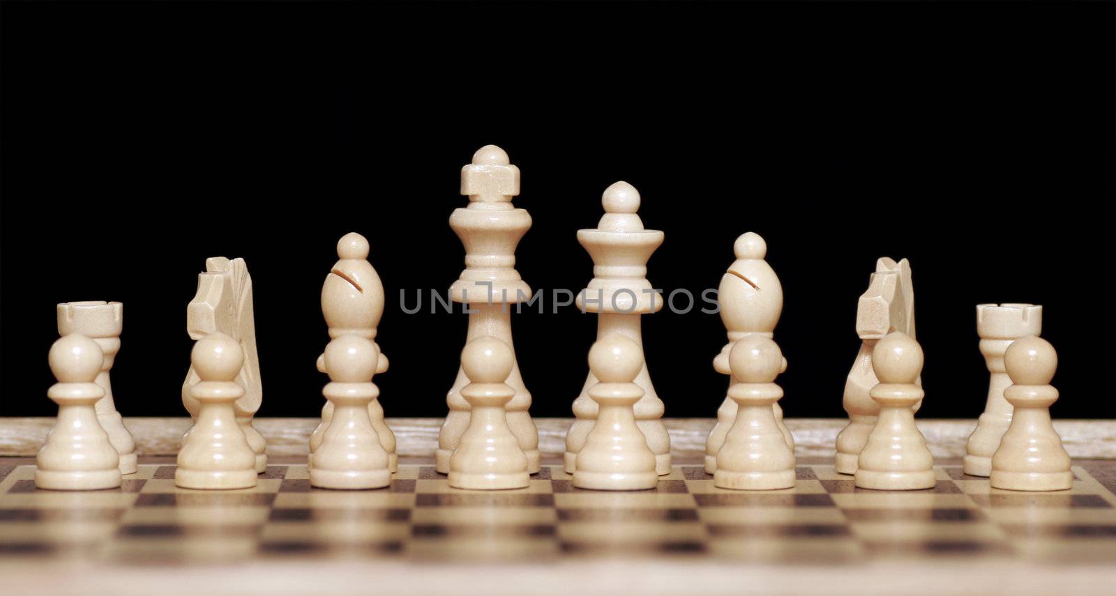 White Chess Pieces On Wooden Chessboard, Focus On Back Row