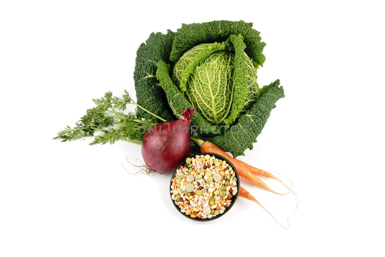 Single green raw cabbage with a single red onion and soup pulses on a reflective white background