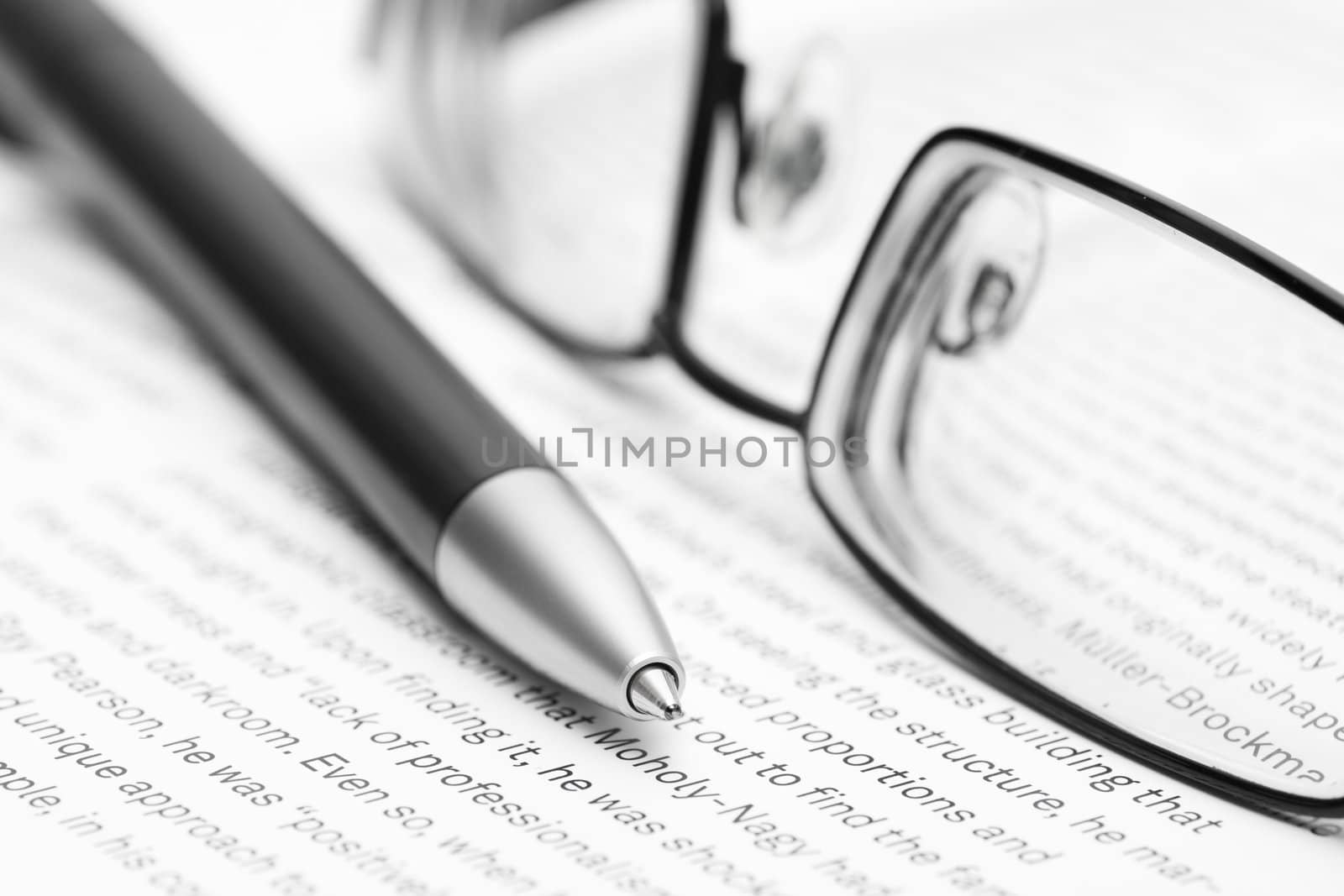 Open book with eyeglasses and pen in black and white