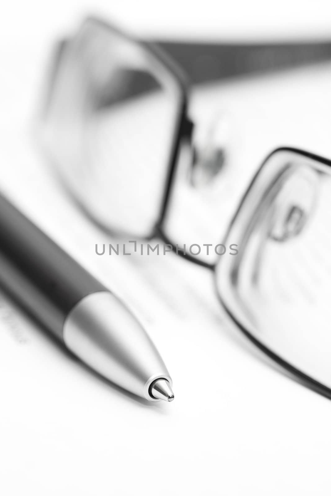 Open book with eyeglasses and pen in black and white