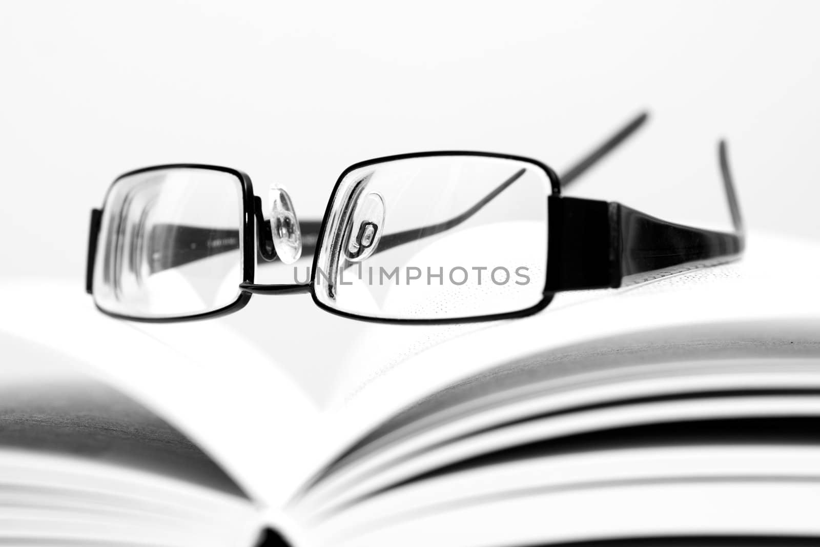 Eyeglasses on open book in black and white