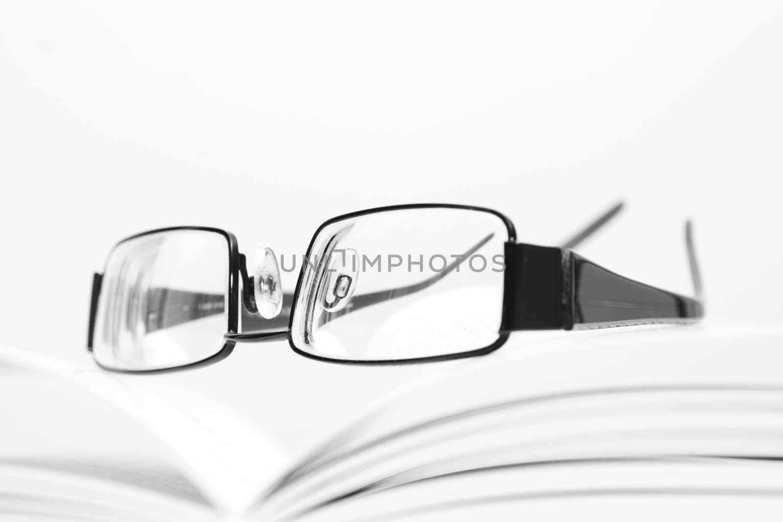 Eyeglasses on open book in black and white