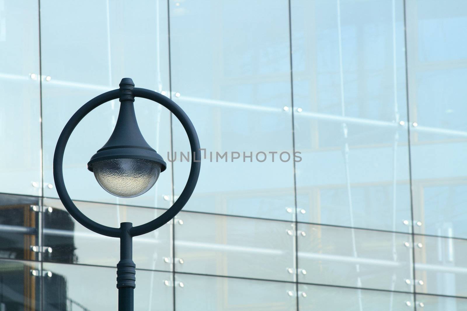 Modern street lamp on glass building wall background with copy space