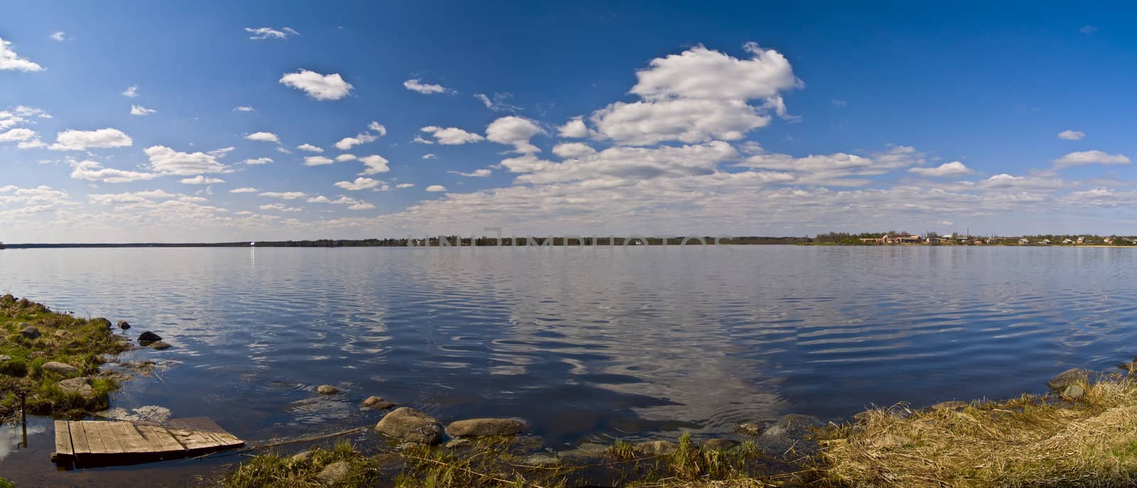 Panoramic show of the sky reflected on rural lake