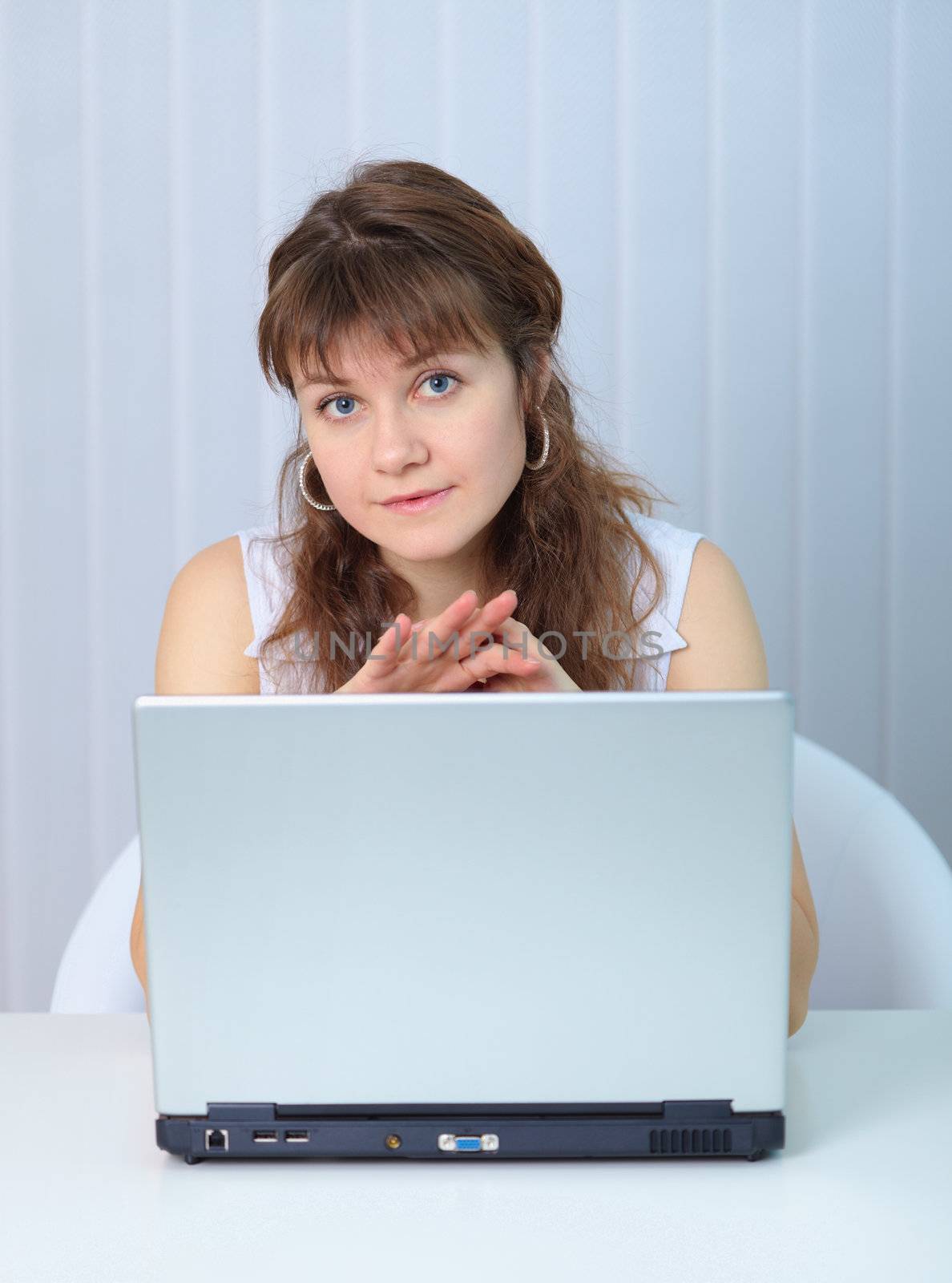 The young beautiful woman sits with the big laptop