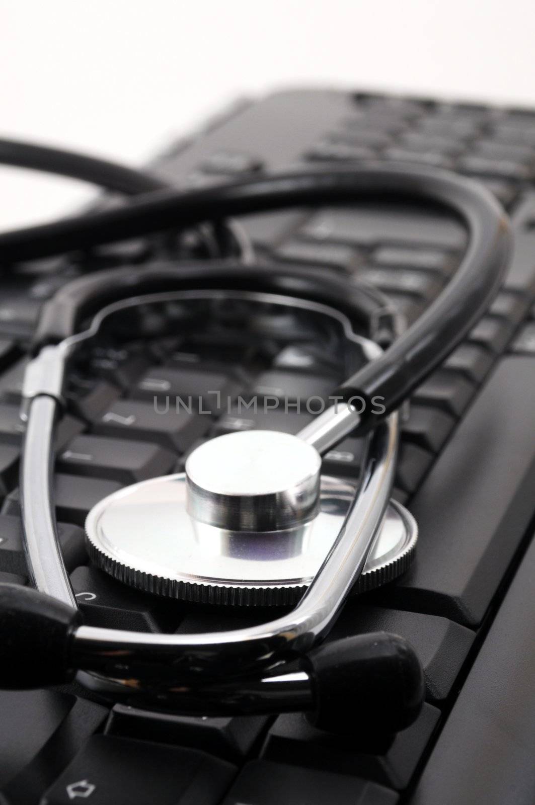 stethoscope on computer keyboard showing medical or pc support concept