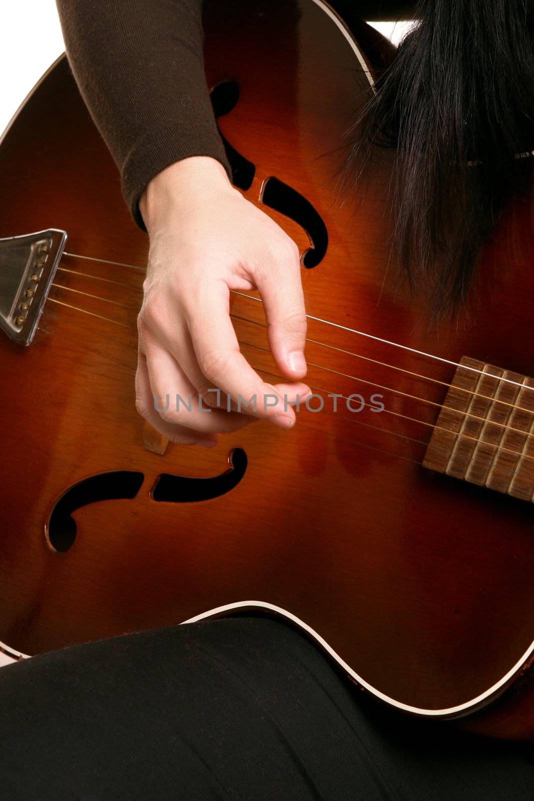 Hands melodically strumming an acoustic guitar