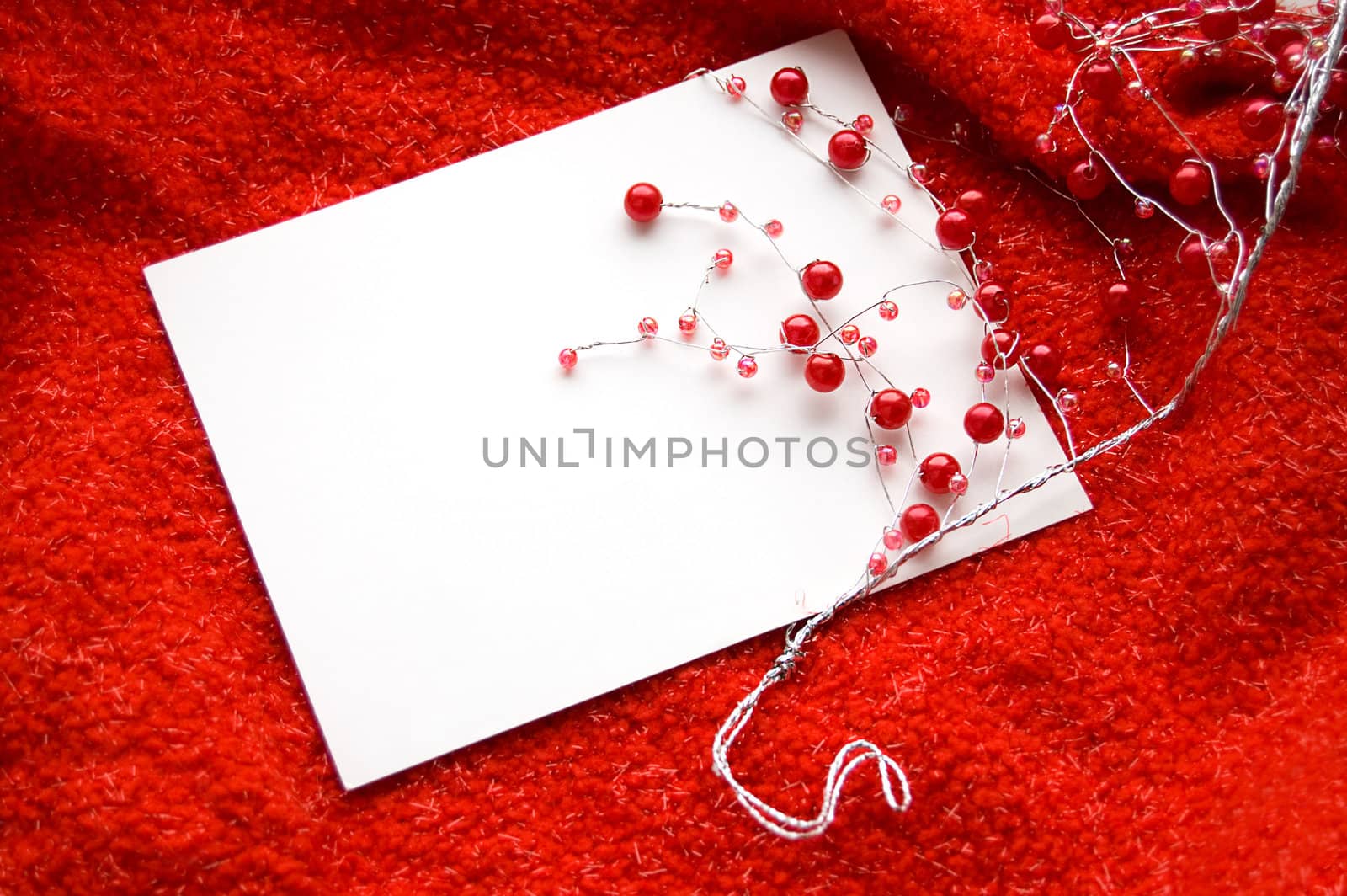 White blank note with red beads decoration on red background