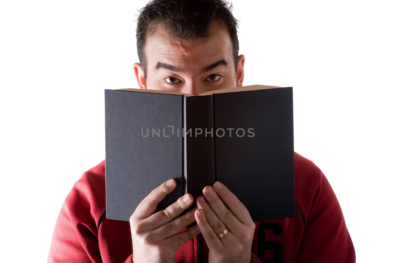 A young man reading a book with a surprised expression on his face.