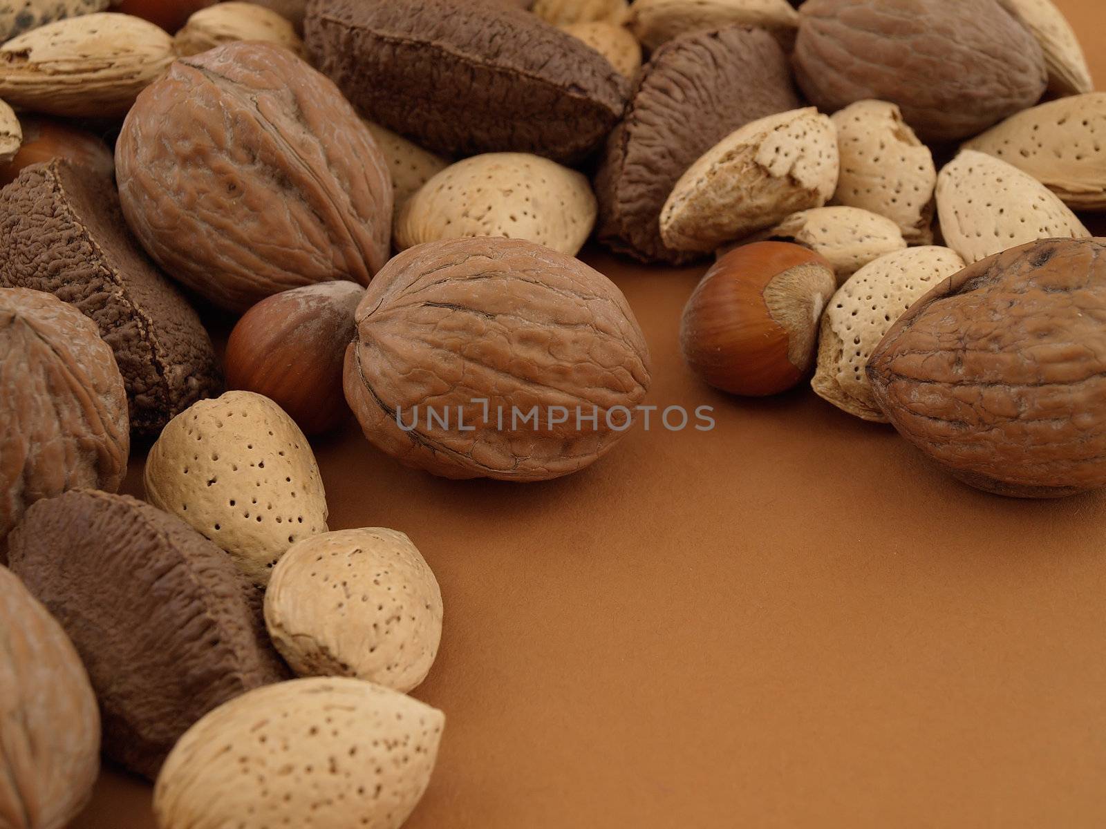 Several different types of nuts on a tan background, with room for text.