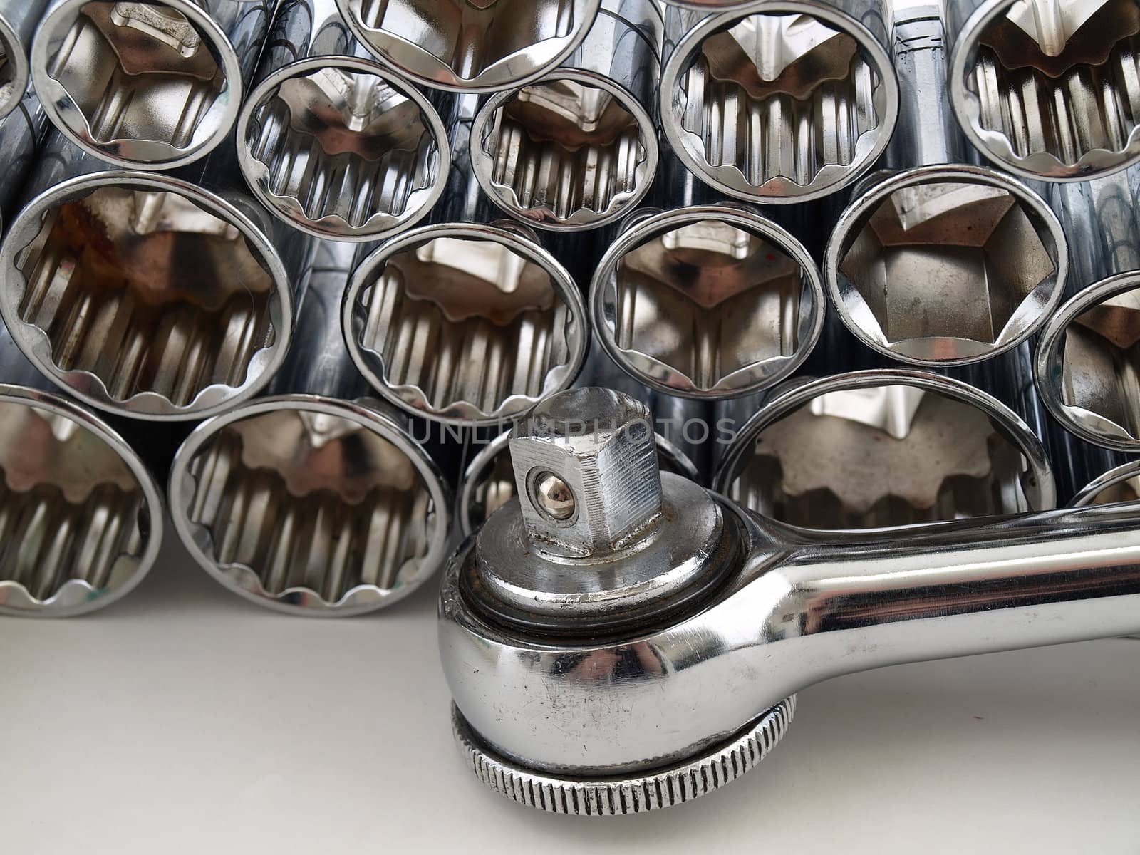 Sockets for a socket wrench stacked together over a white background.