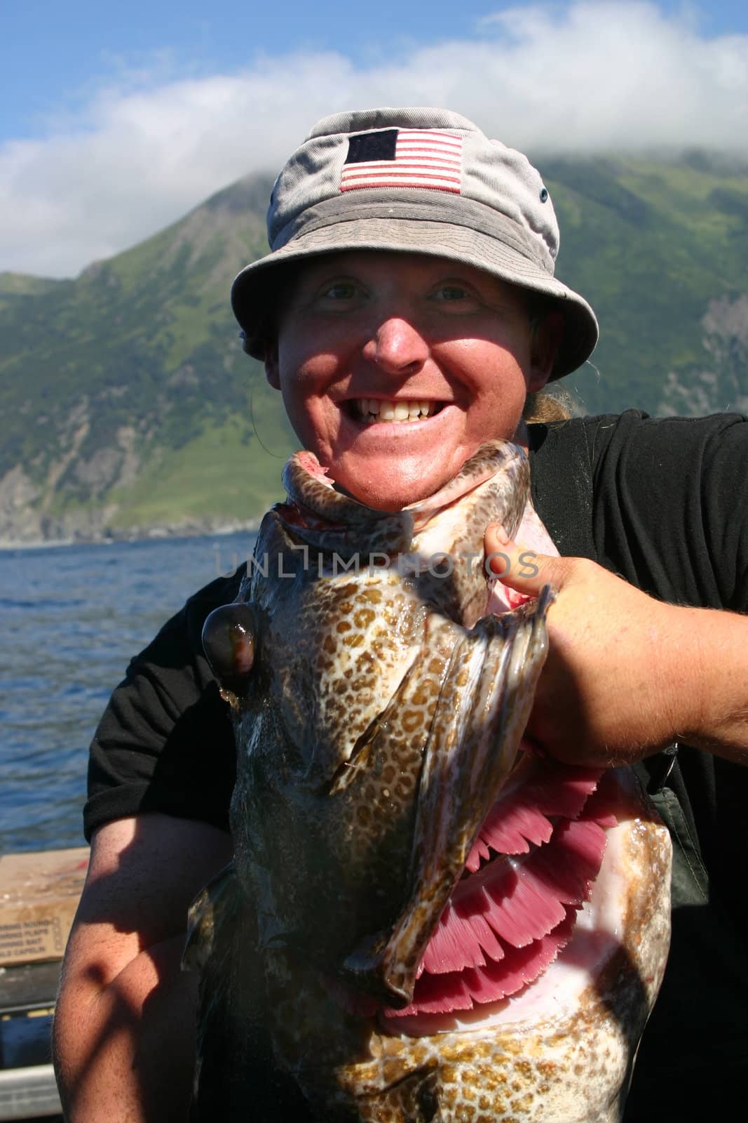 Fisherman demonstrates the size of the Lingcod just pulled from the Katchemak Bay waters of Alaska.  