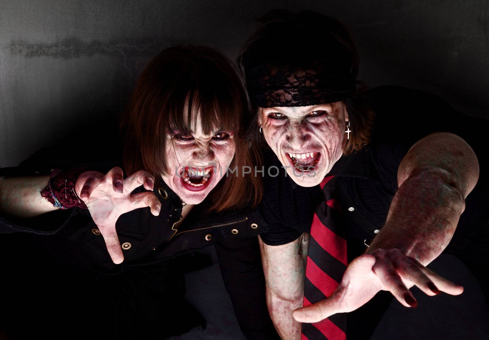 Male and female bloody zombies reaching out