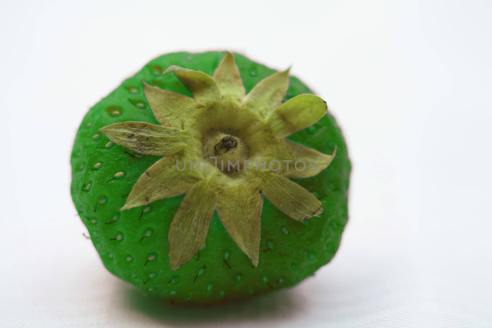 A close up of a fresh green strawberry