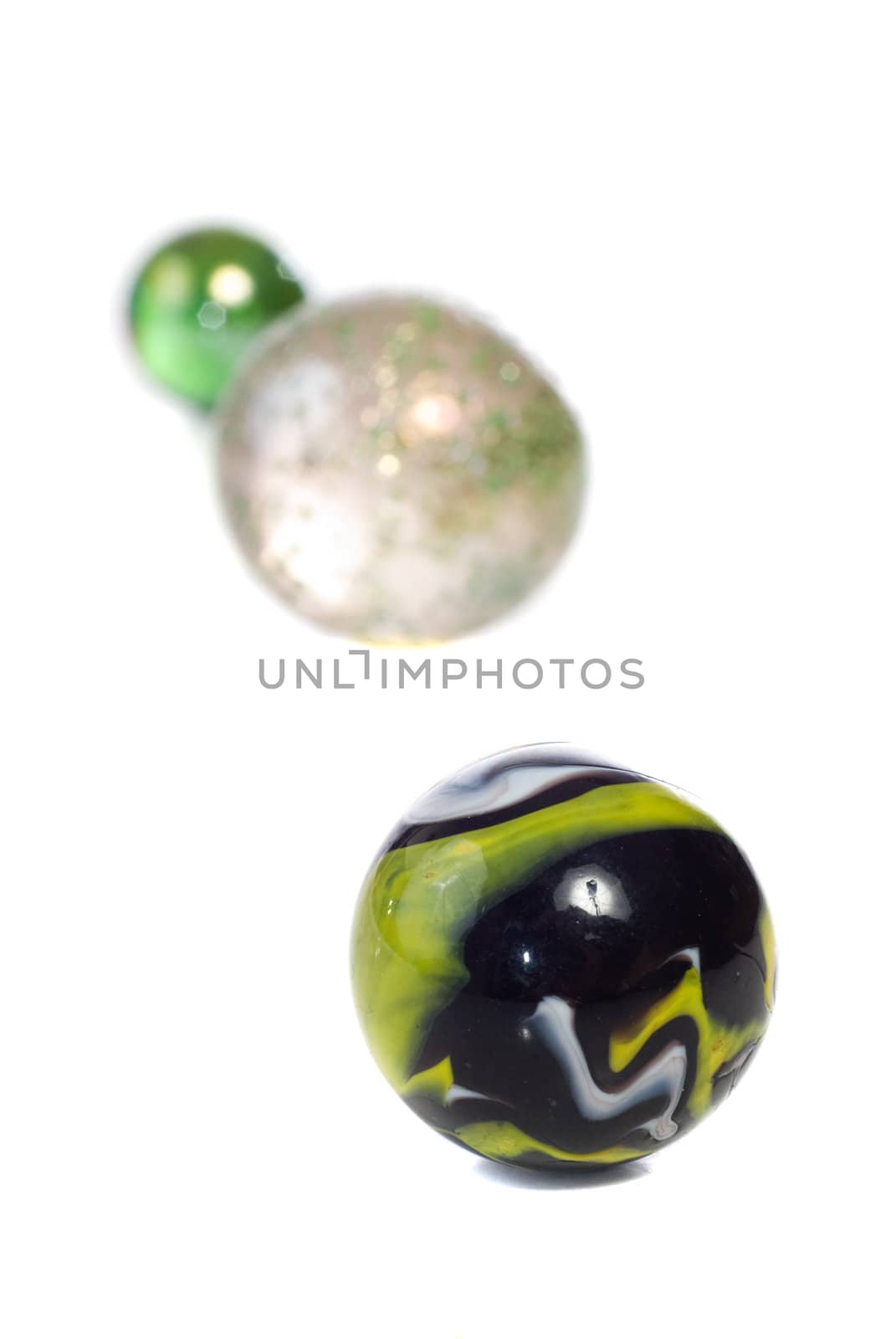 Closeup view of a game of marbles, shot against a white background
