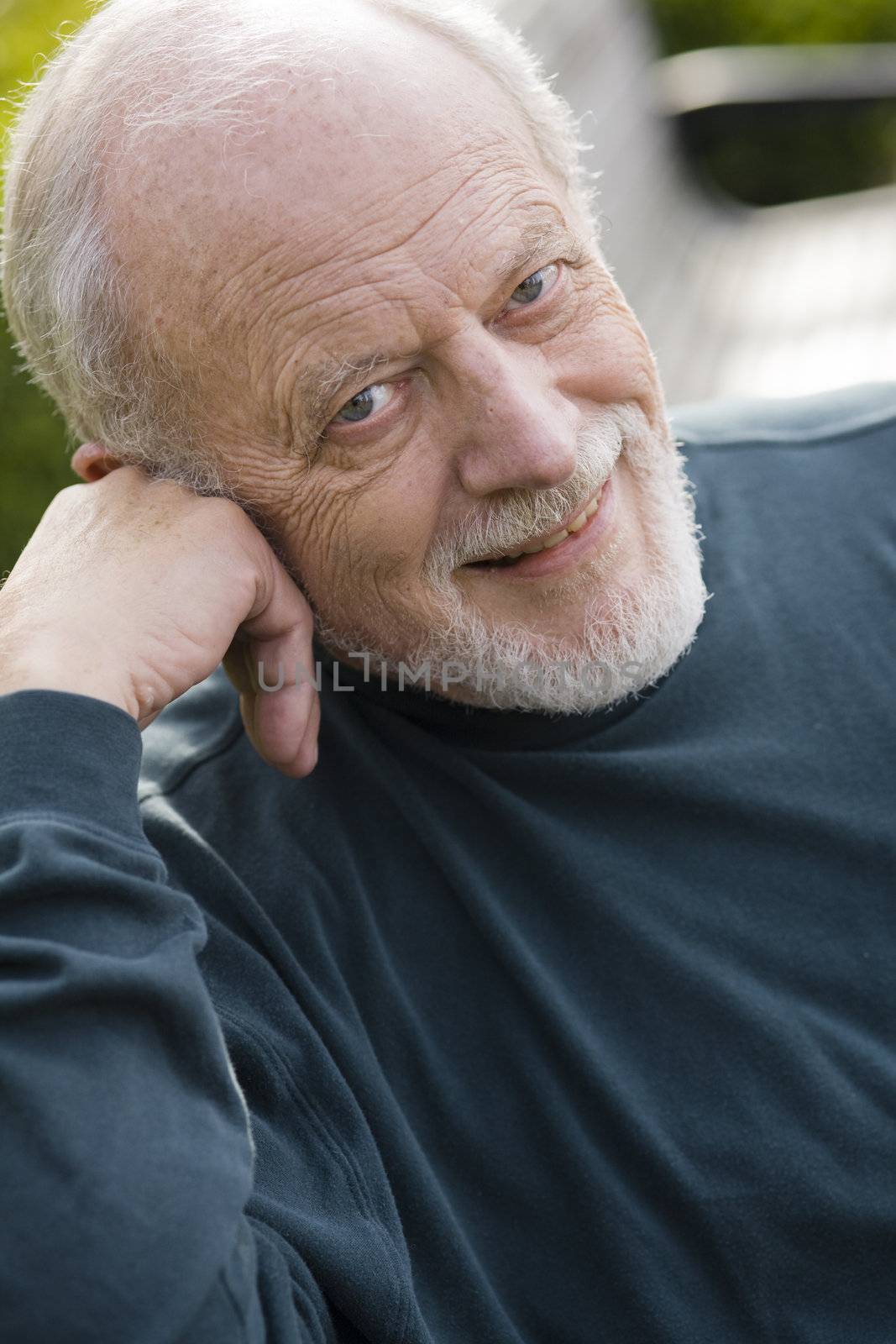 Portrait of an Elderly Gentleman Sitting on a Bench in a Park