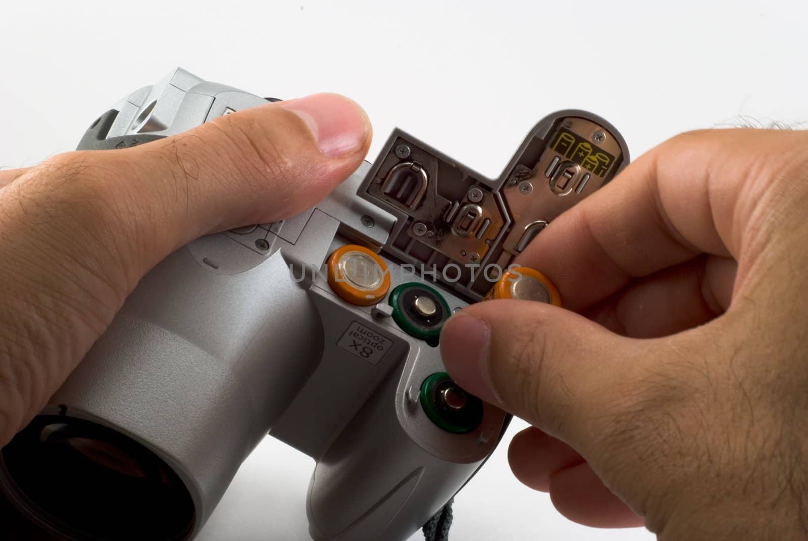 The man inserts a batterys into a digital camera