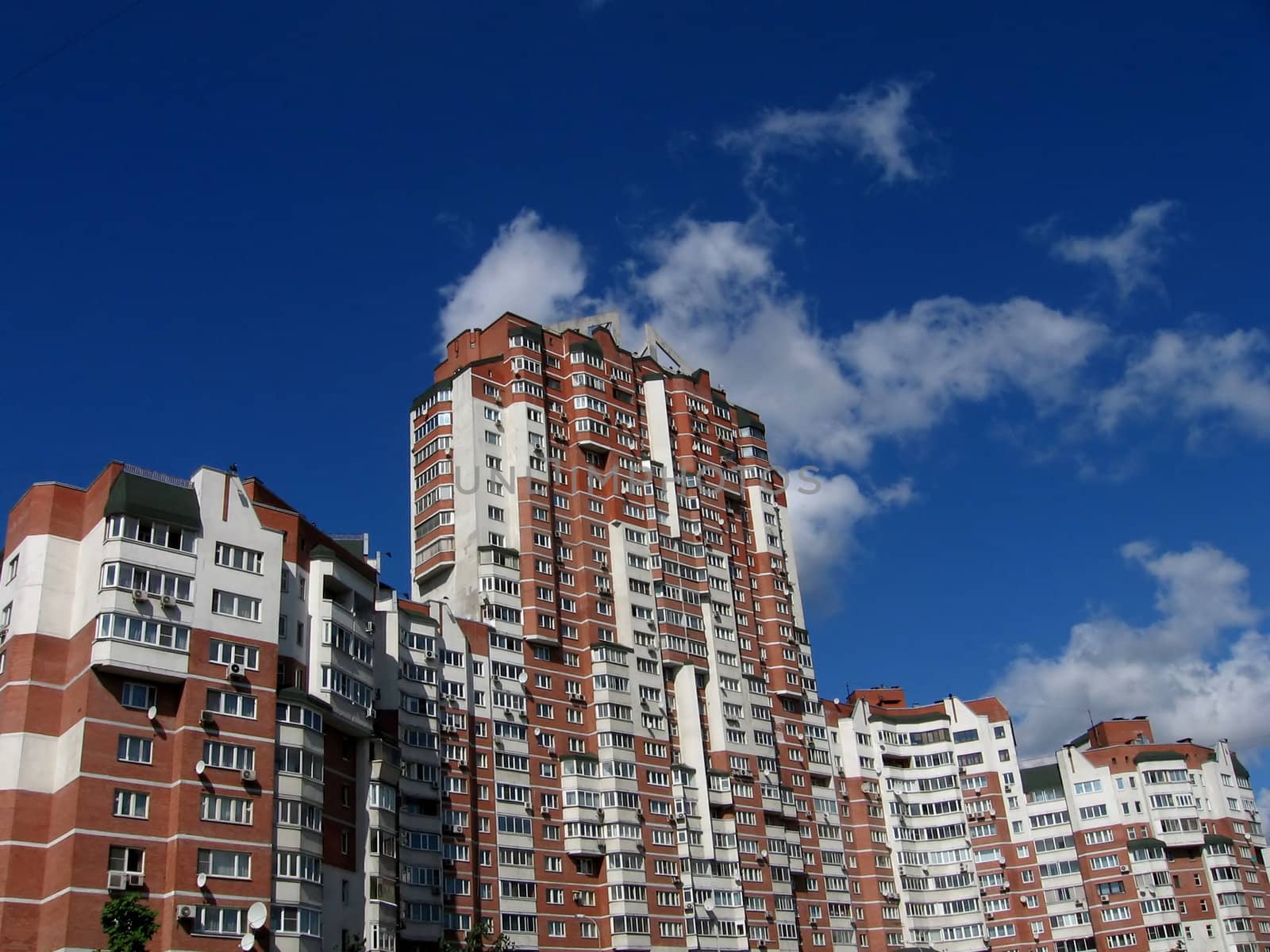 Beautiful red house on a background of blue sky with clouds