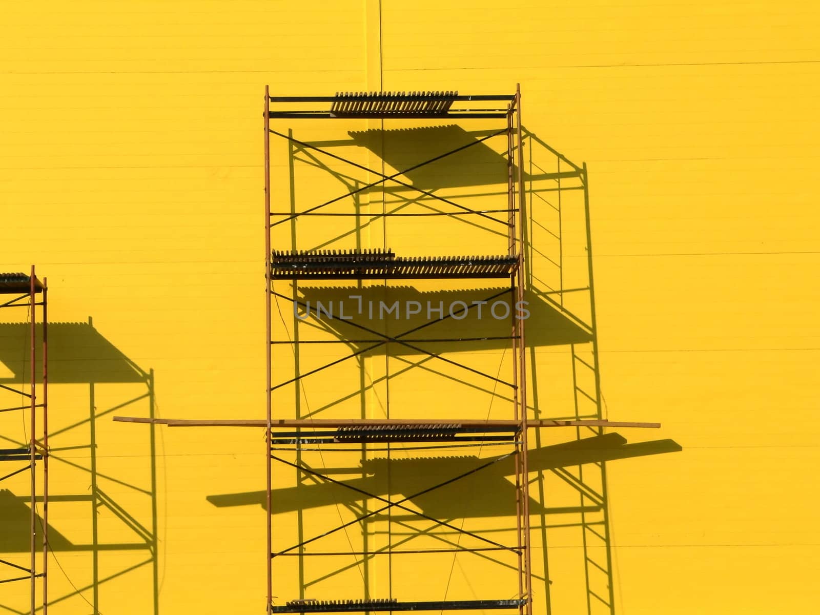 Constructions scaffolding on the yellow wall background